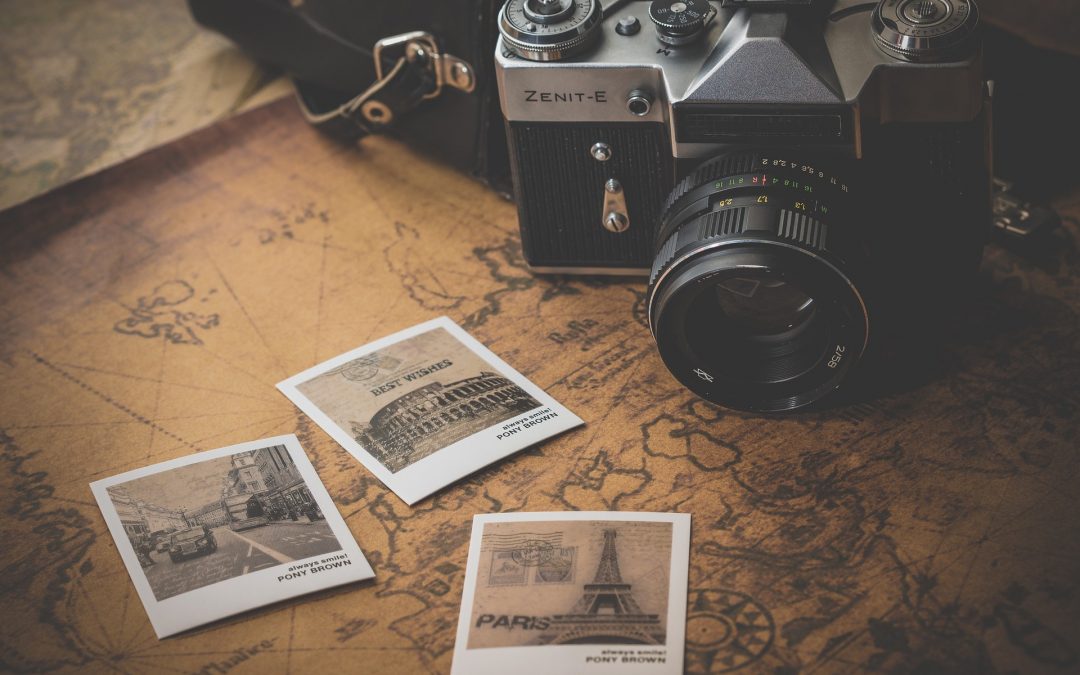 Polaroids of European destinations and a camera on top of a world map